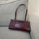 Brown leather handbag on a gray sofa