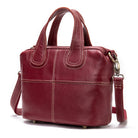 Red leather handbag with a shoulder strap on a white background