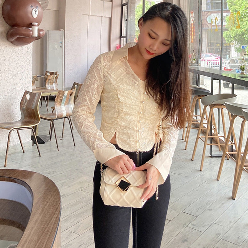 Woman holding a beige handbag in a casual indoor setting