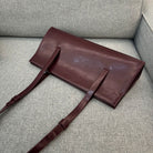 Brown leather bag on a gray sofa