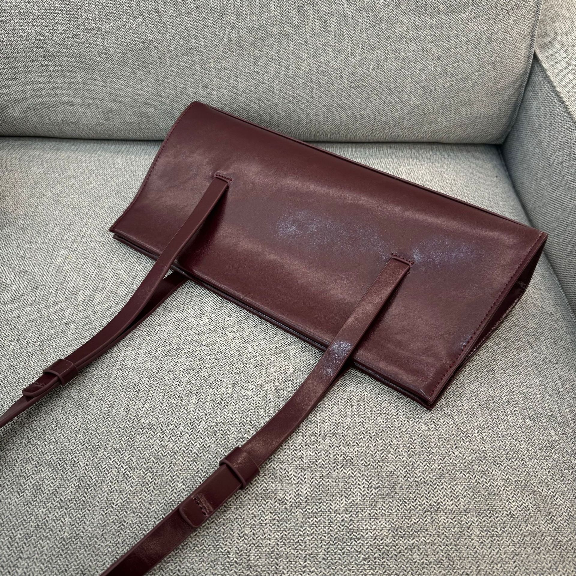 Brown leather bag on a gray sofa