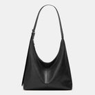 Black leather handbag on a light gray background