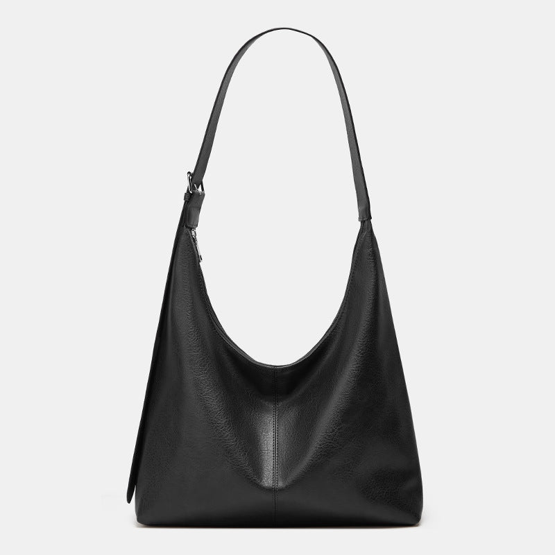 Black leather handbag on a light gray background