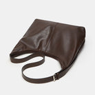 Brown leather bag with a strap on a white background
