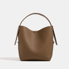 Brown leather handbag on a light gray background