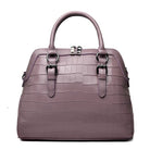 Purple handbag with crocodile texture on a white background