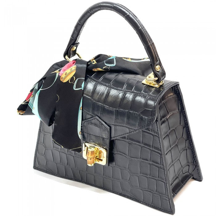 Black crocodile-patterned handbag with floral detail on a white background
