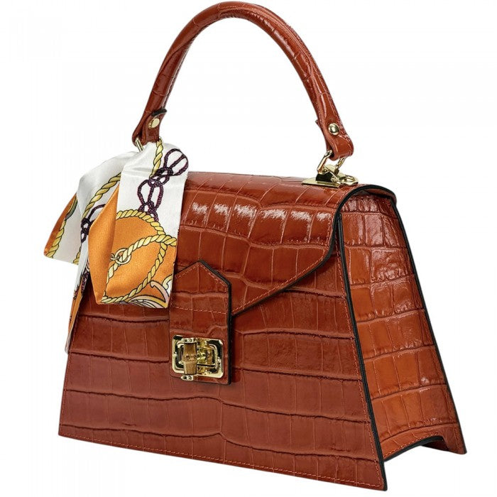 Brown crocodile-patterned handbag with a gold clasp and a matching scarf on a white background