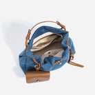 Blue denim bag with brown leather accents on a white background