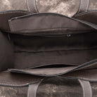 Close-up of a brown leather bag with visible stitching details.