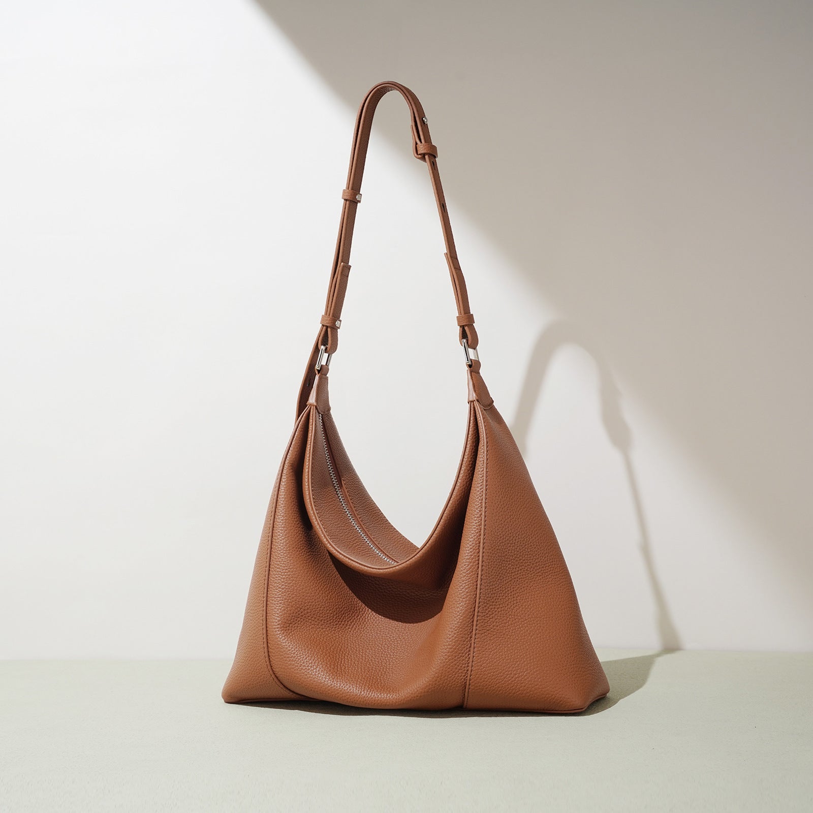 Brown leather handbag on a light beige background