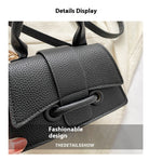 Black leather handbag with a strap, displayed against a neutral background.