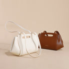 White and brown handbags on a beige background