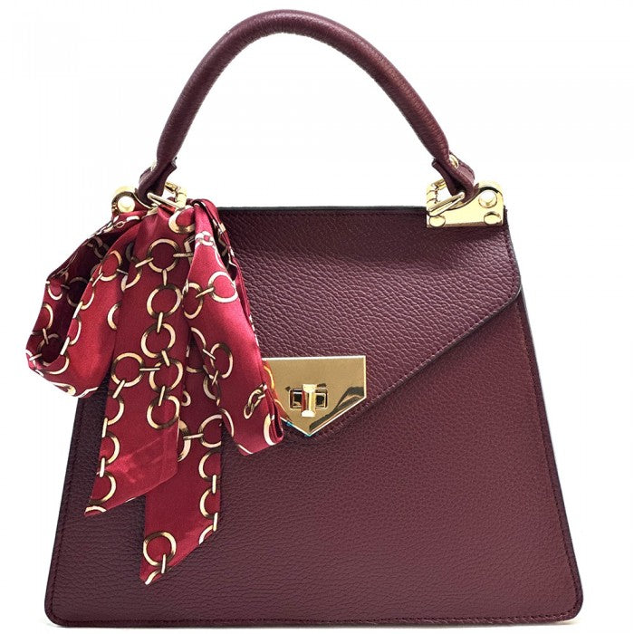 Maroon handbag with gold accents and a red scarf on a white background