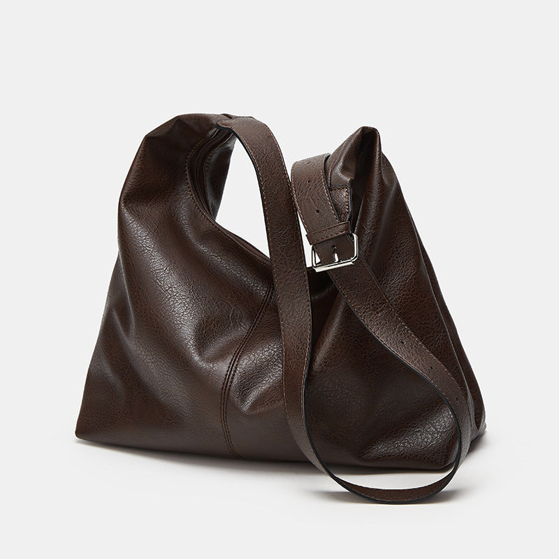 Brown leather handbag on a light gray background