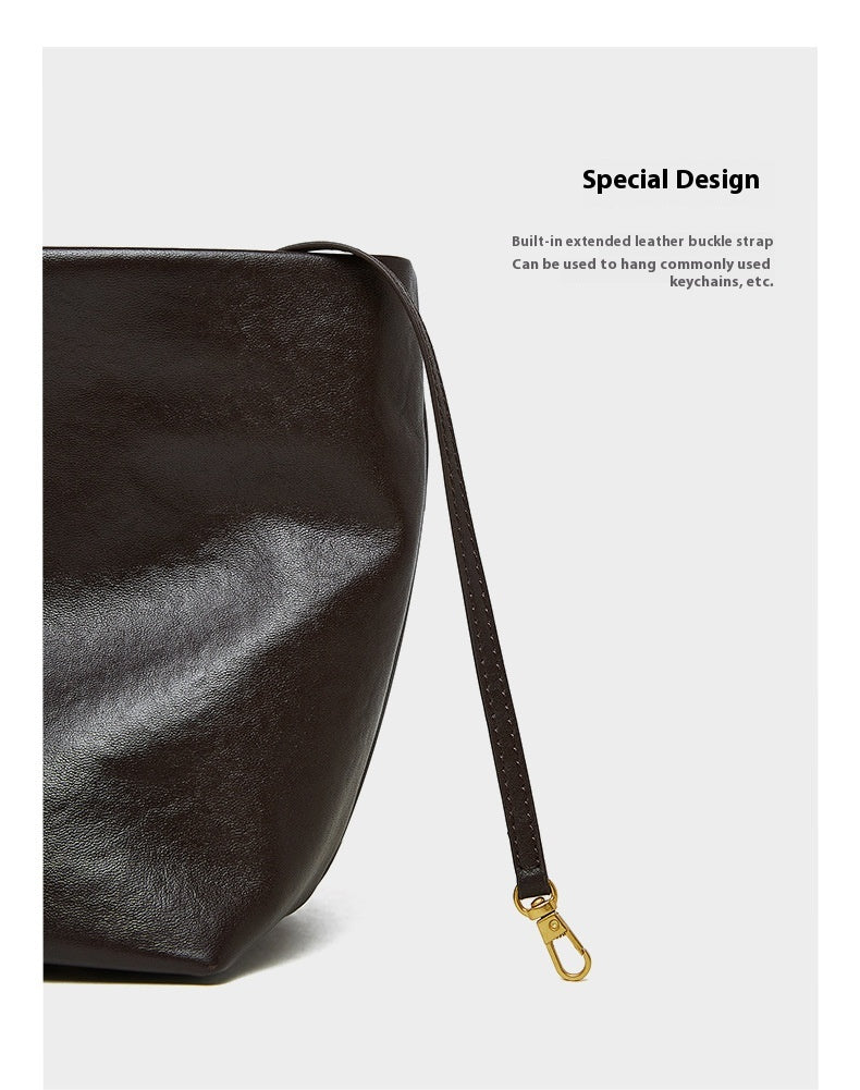 Black leather bag with an extended leather strap on a white background