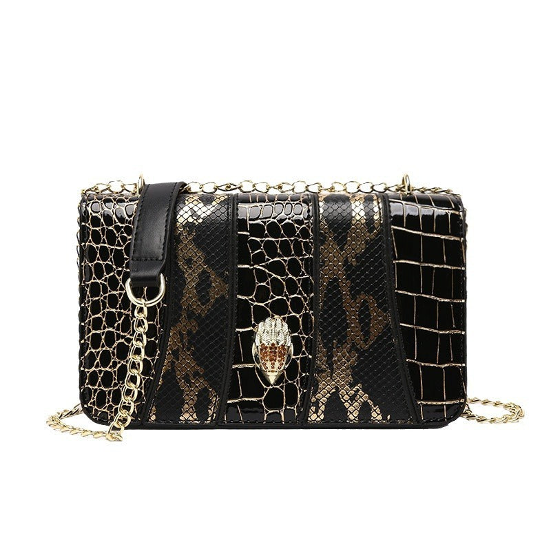 Black and gold patterned handbag with a chain strap on a white background