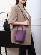 Person holding a purple handbag in a neutral setting