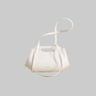 White handbag with a strap on a beige background