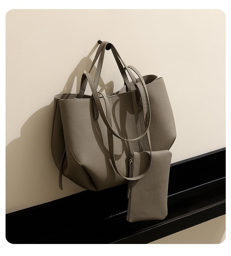 Gray handbag on a black surface with a beige background