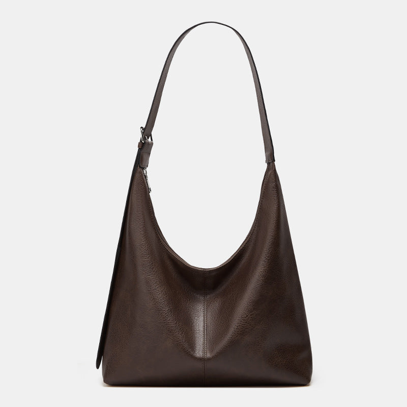 Brown leather handbag on a light gray background