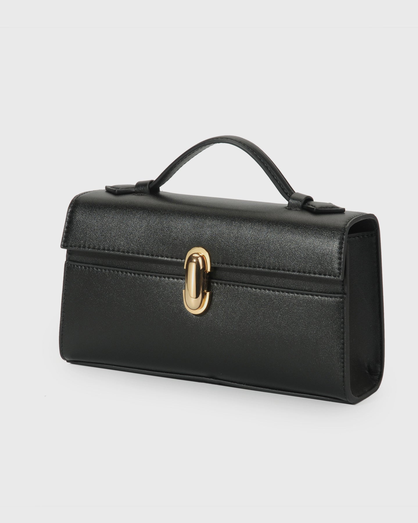 Black handbag with a gold clasp on a light gray background