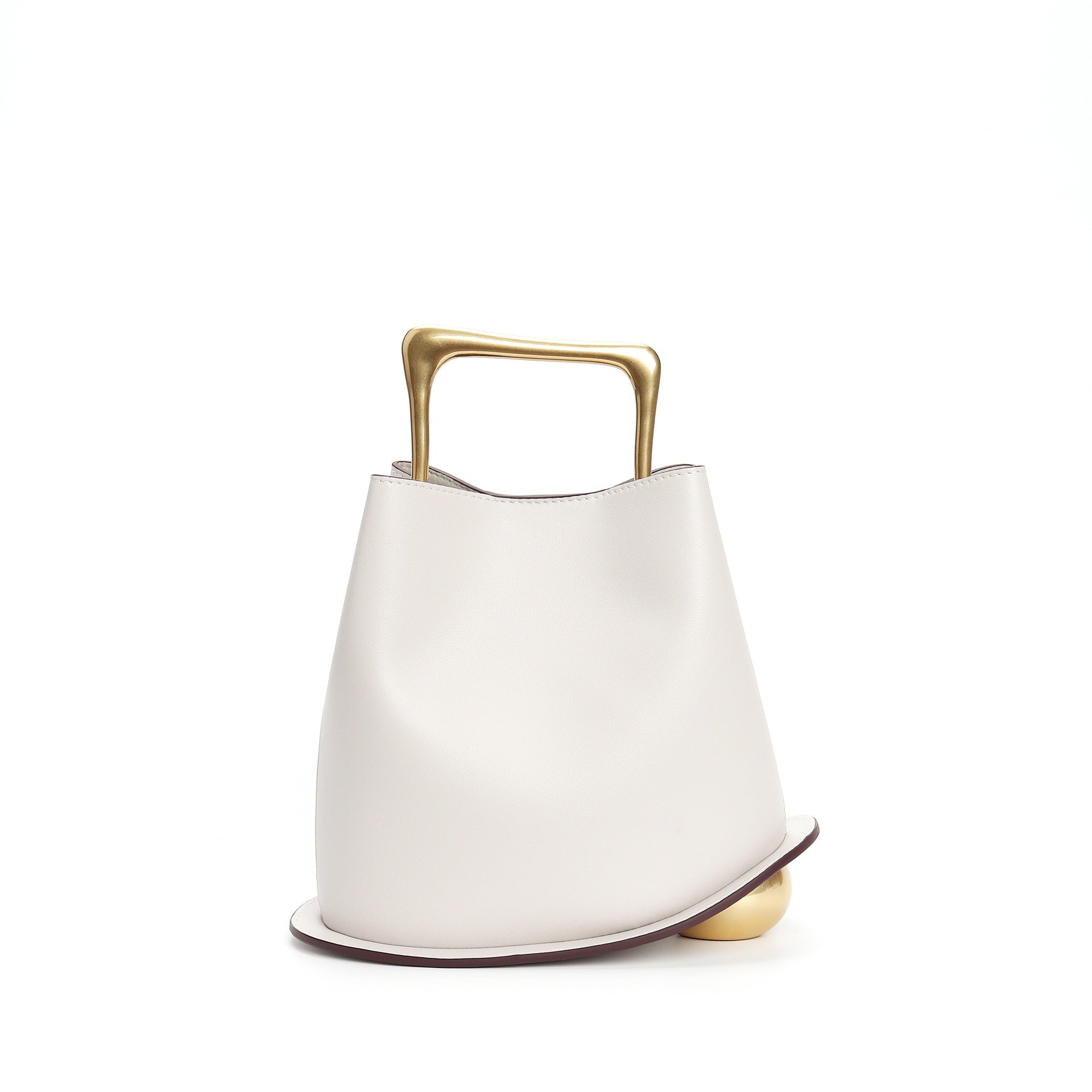 White handbag with gold handle and base on a white background
