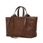 Brown leather tote bag with a shoulder strap on a white background