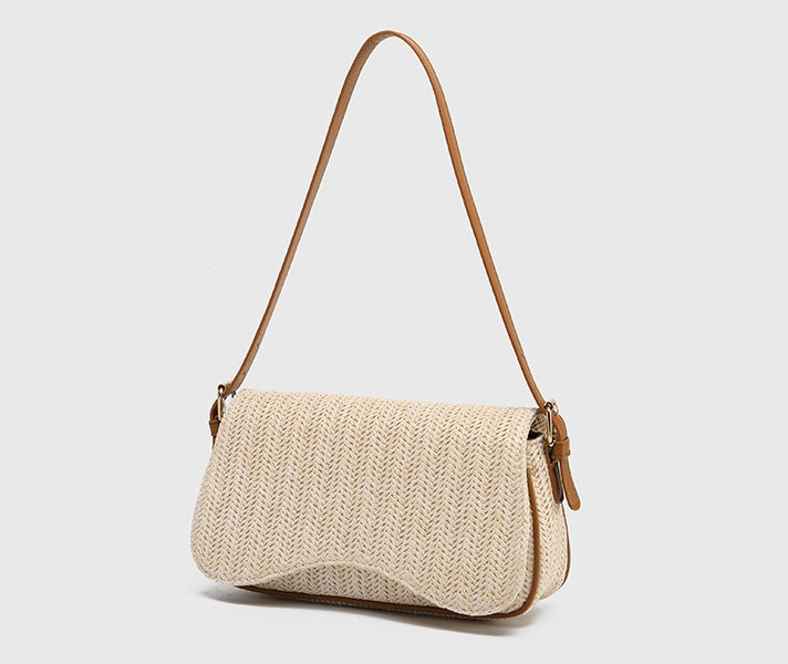 Beige woven handbag with brown leather strap on a light gray background