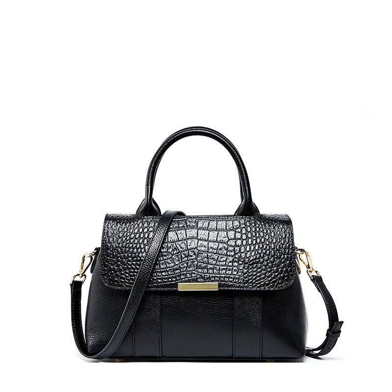 Black textured handbag with a gold clasp on a white background