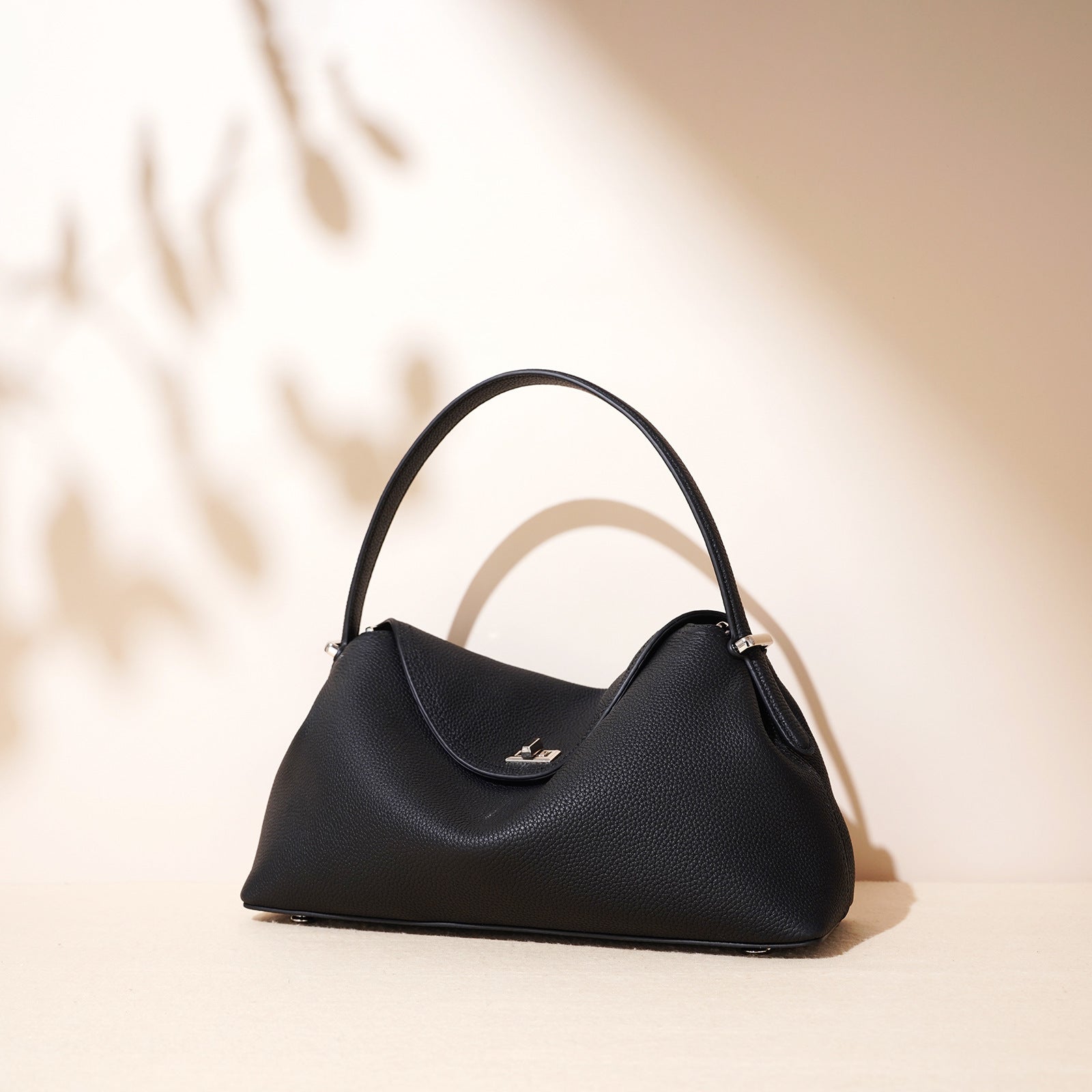 Black handbag on a beige background