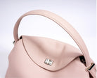 Pink handbag with a silver clasp on a light gray background