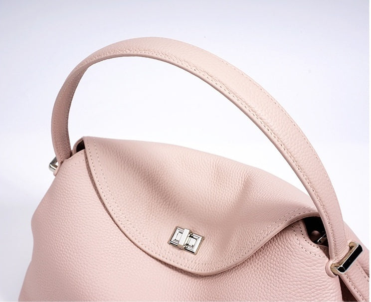Pink handbag with a silver clasp on a light gray background