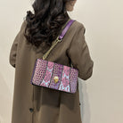 Person wearing a brown coat with a patterned handbag on a beige background