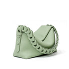 Mint green handbag with a braided chain strap on a white background