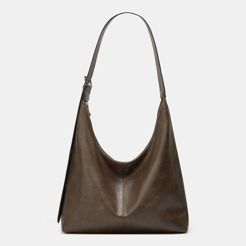 Brown leather handbag on a light gray background
