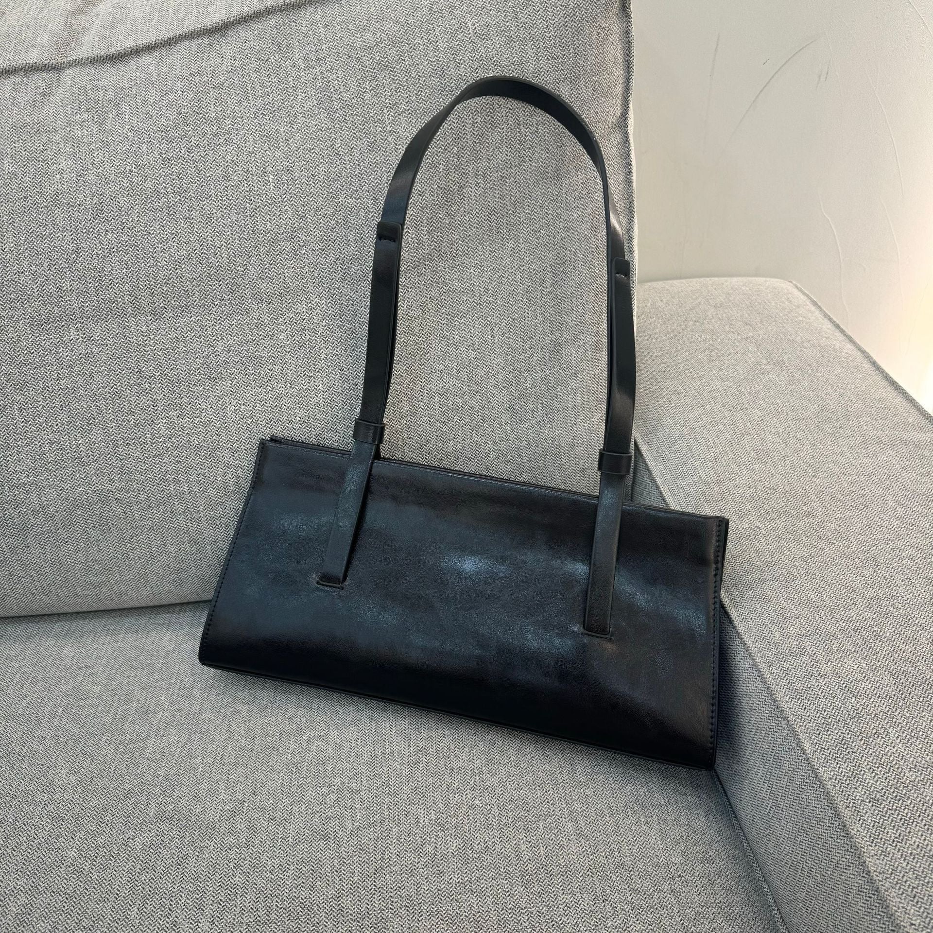 Black handbag on a gray textured surface