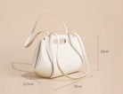 White handbag with dimensions on a beige background