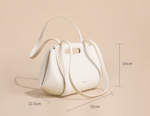White handbag with dimensions on a beige background