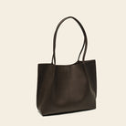 Brown leather tote bag on a beige background