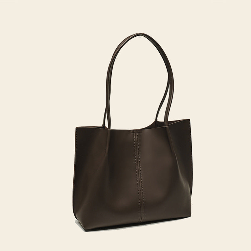 Brown leather tote bag on a beige background