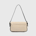 Beige woven handbag with a black strap on a light gray background