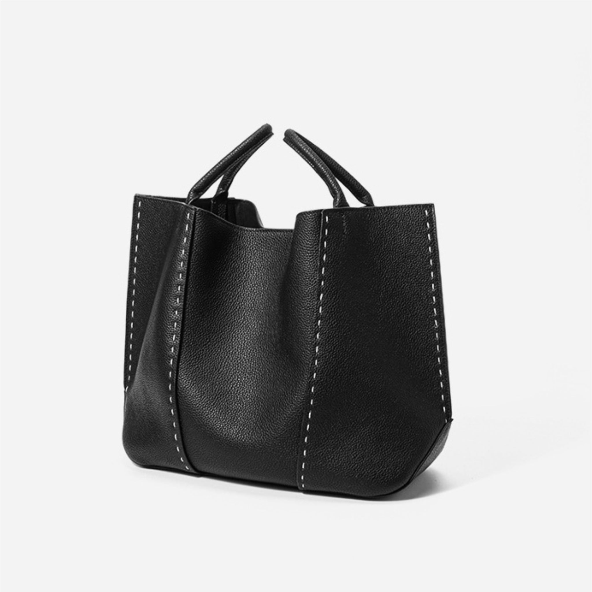 Black leather handbag with visible stitching on a white background