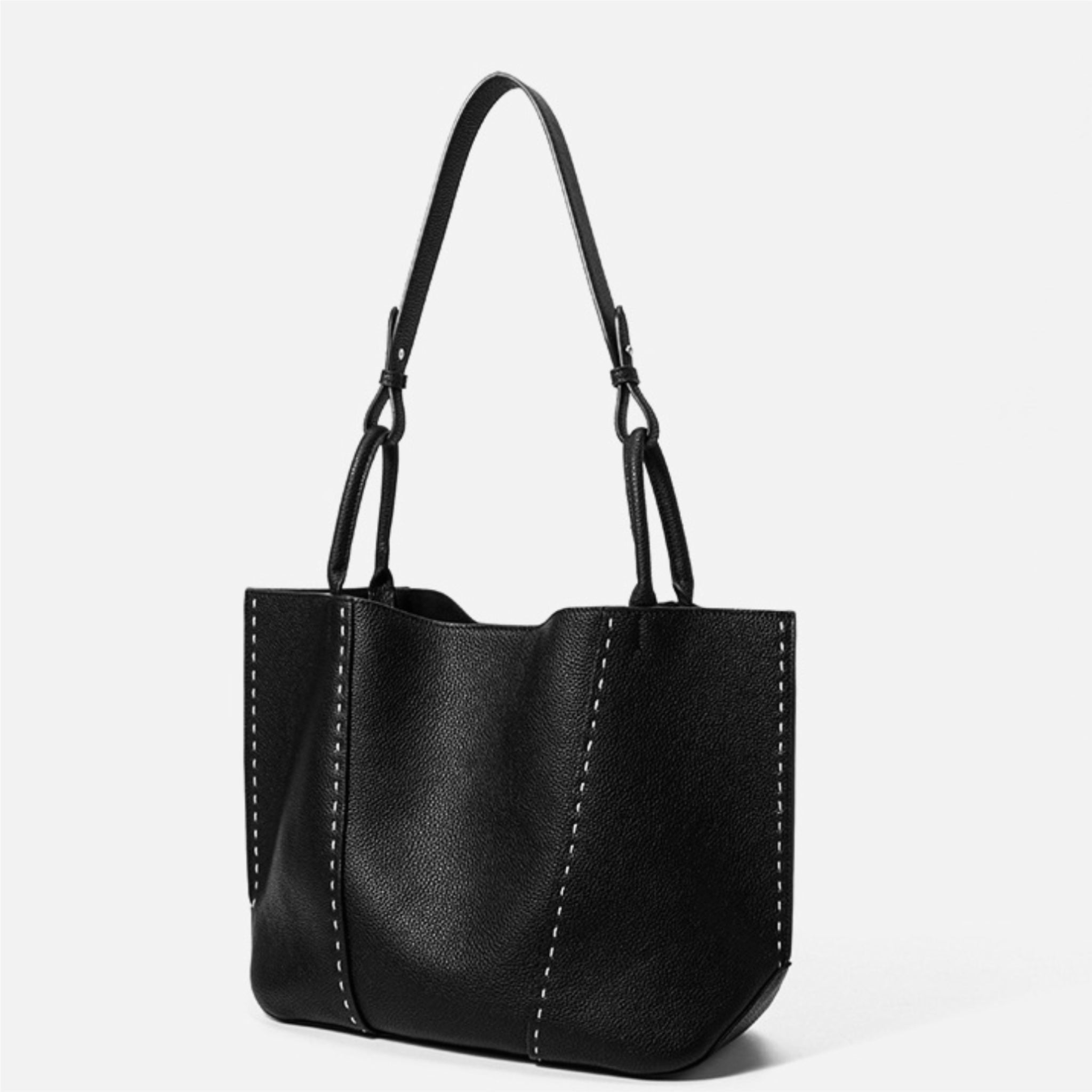 Black leather handbag with a strap on a white background
