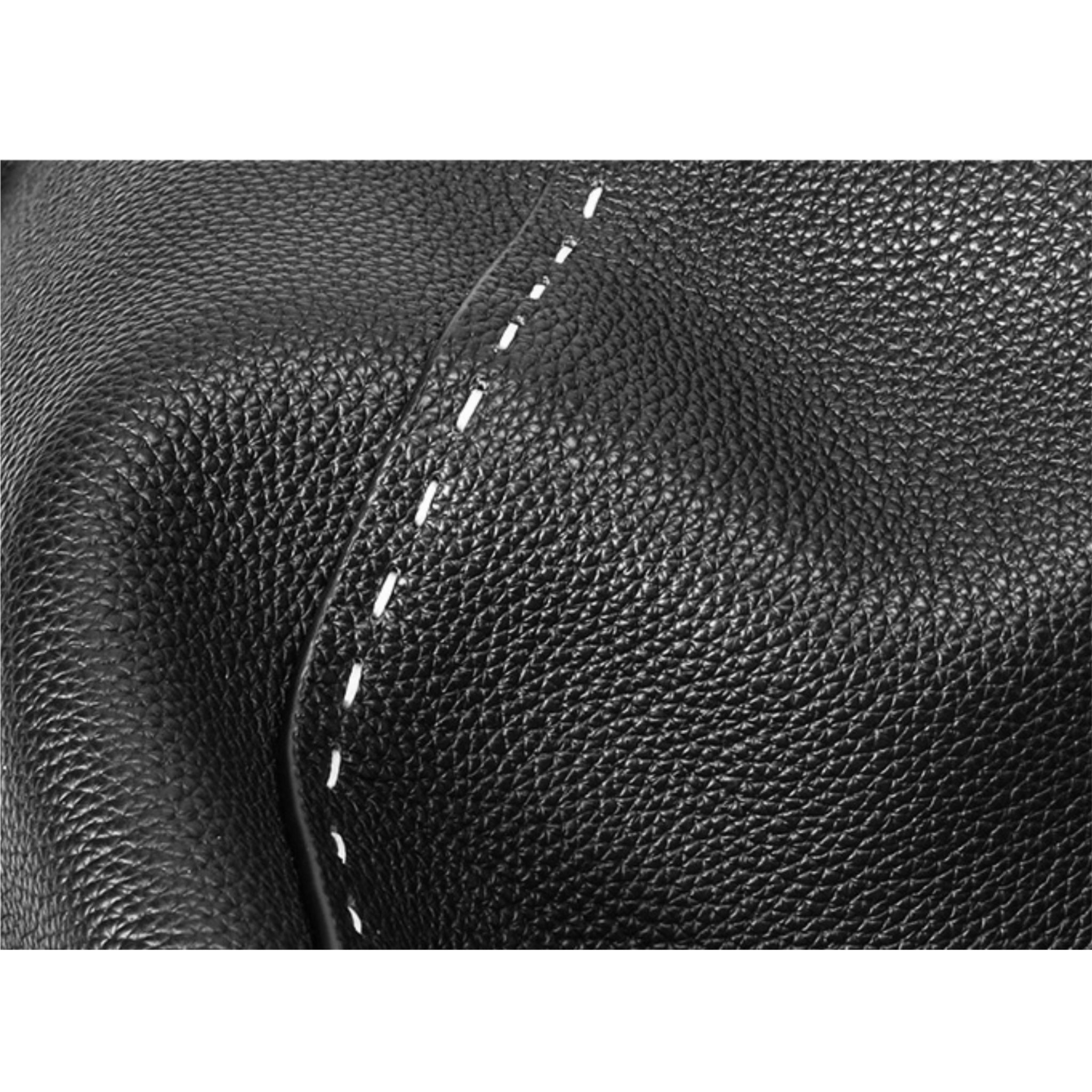 Close-up of black leather with white stitching on a white background