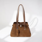Brown handbag with a strap on a white background