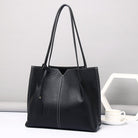 Black leather tote bag on a light gray background