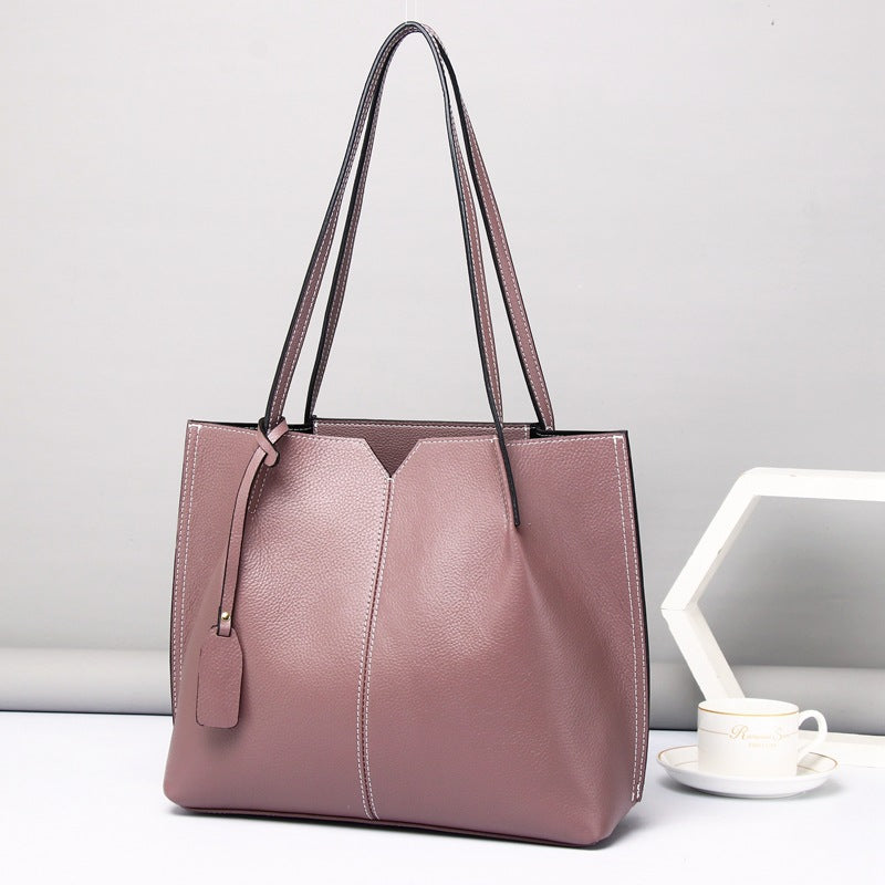 Pink handbag on a white surface with a light gray background