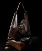 Brown leather handbag on a black background