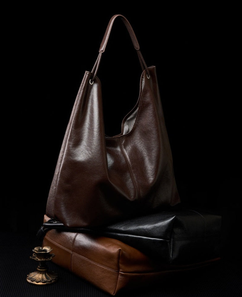 Brown leather handbag on a black background
